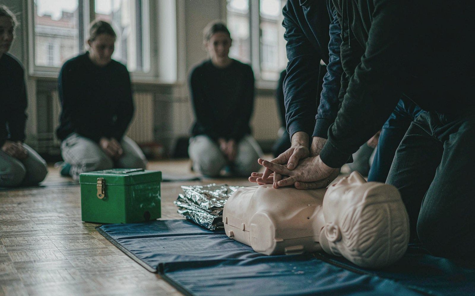 First aid practice with chest compressions on a training manikin