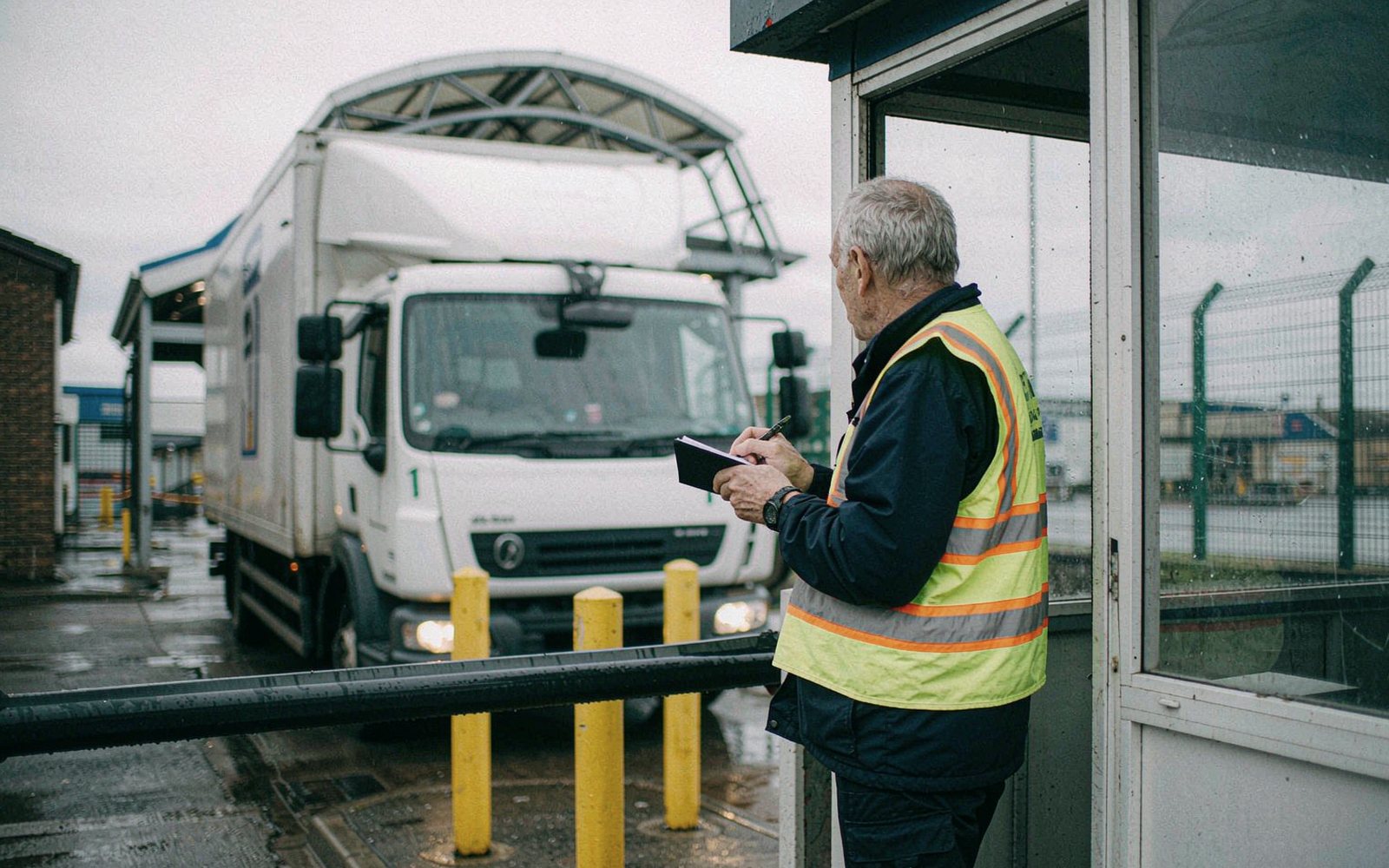 Gatehouse officer logging a delivery vehicle at the barrier