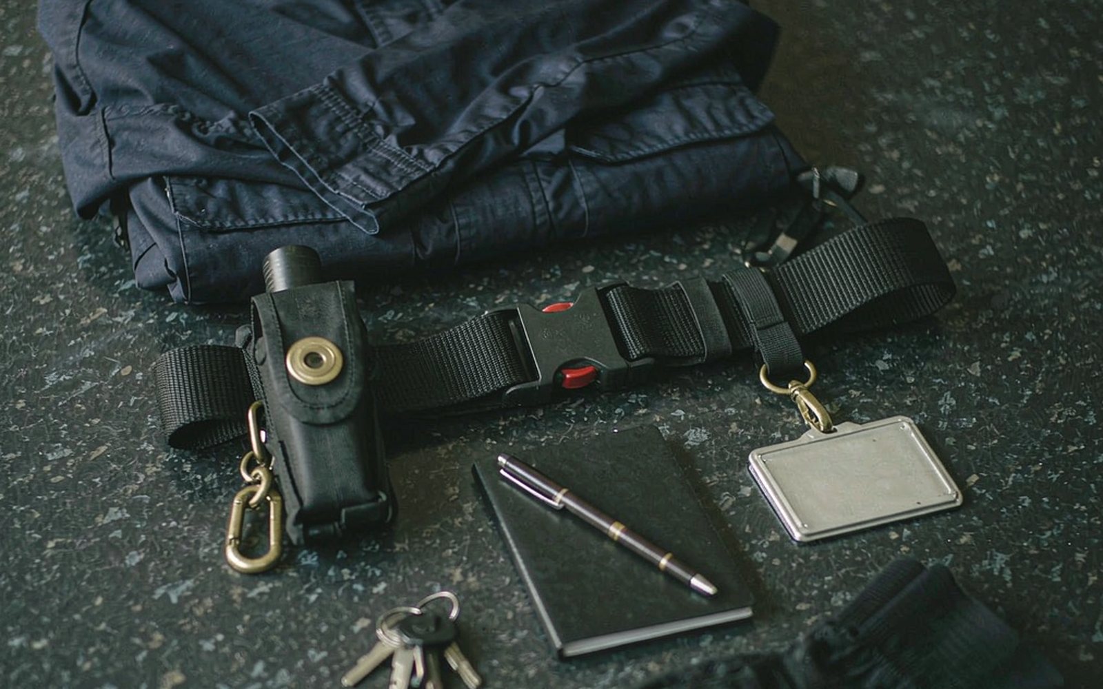 Officer kit laid out: jacket, badge holder, torch and notebook
