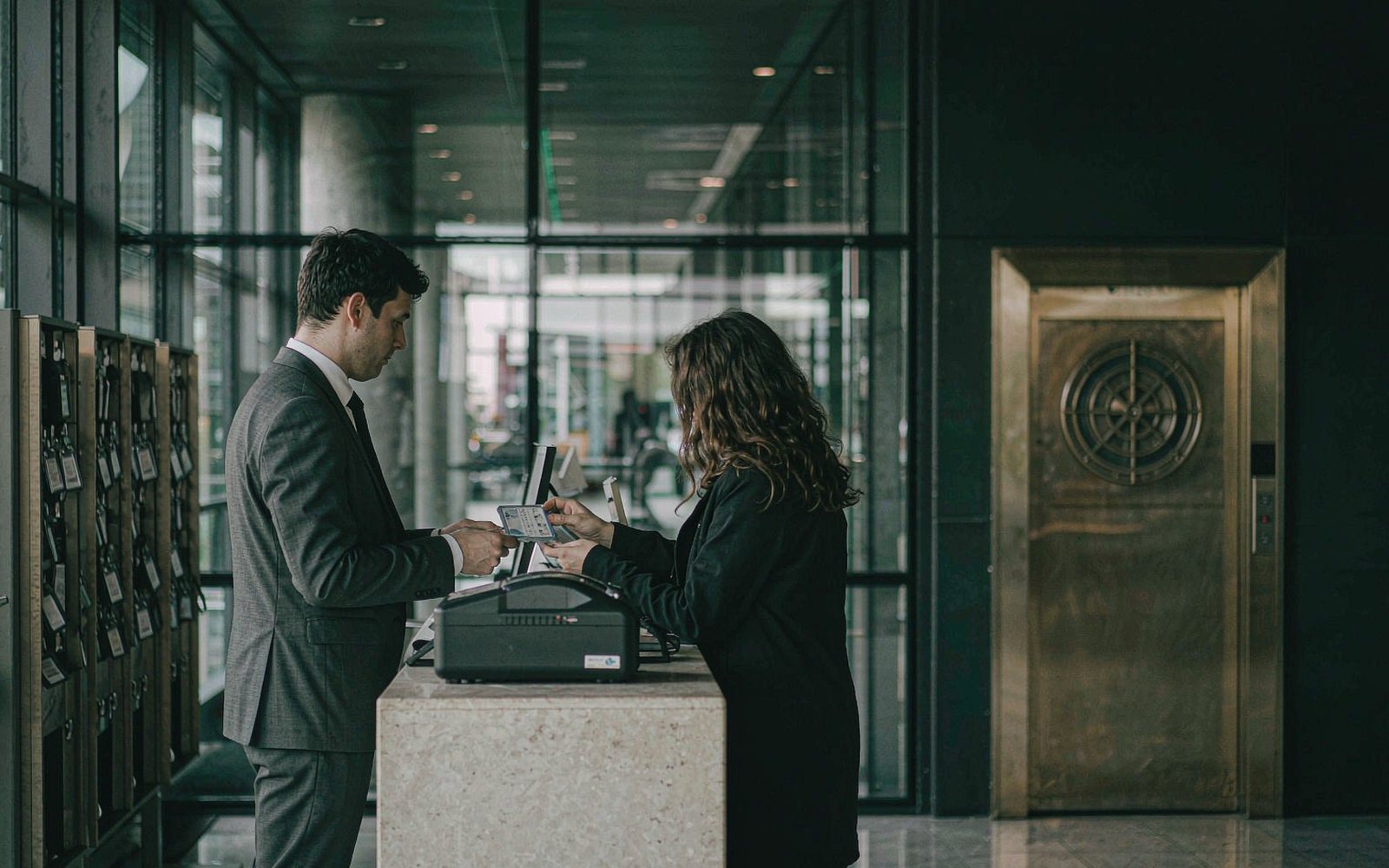 Reception officer checking a visitor pass at a corporate reception desk